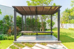 Modern home entry featuring a dark gray powder-coated aluminum canopy with integrated LED lights installed above a modern front door.