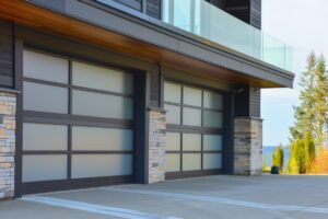 Contemporary Southern California home exterior featuring black-frame modern glass aluminum garage doors with frosted tempered glass panels.